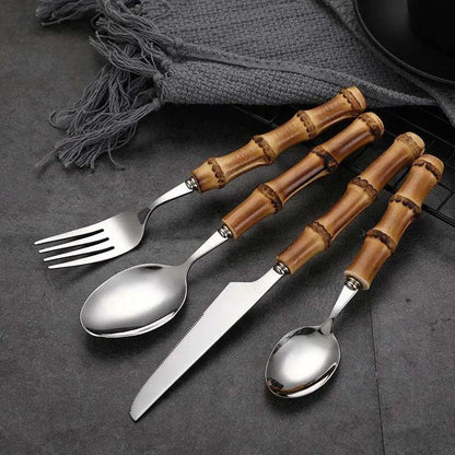 Set of cutlery with bamboo handles on a dark surface