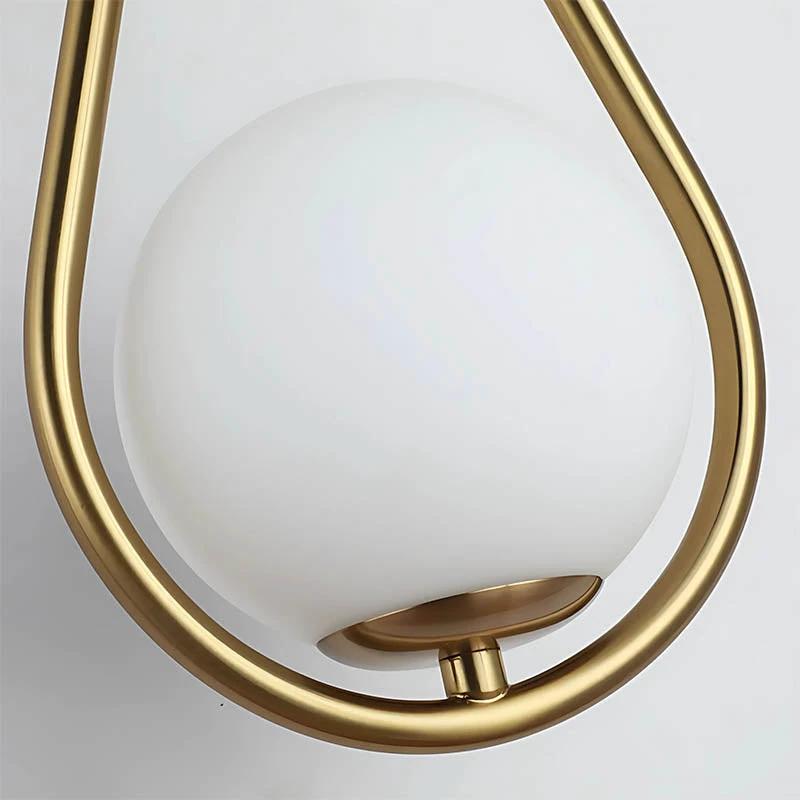 Wall light with Nordic brass frame and frosted glass globe, wall-mounted fixture for a warm, contemporary glow.