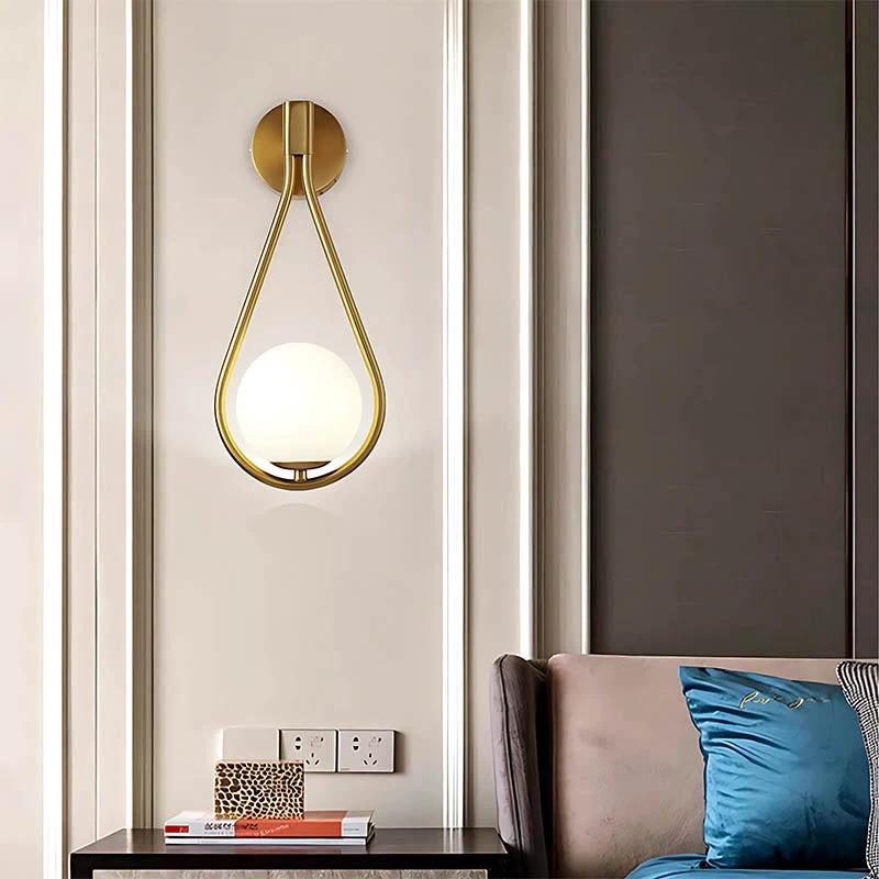 DARBE Nordic Brass Wall Light with frosted globe mounted on living room wall.