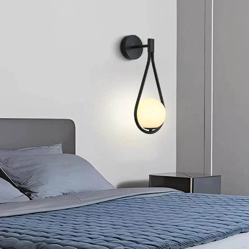DARBE - Nordic Brass Wall Light, Frosted Glass Globe Design mounted on a bedroom wall beside bed, glowing softly.