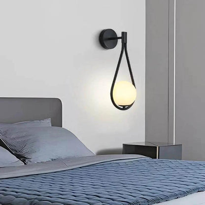 DARBE - Nordic Brass Wall Light, Frosted Glass Globe Design mounted on a bedroom wall beside bed, glowing softly.