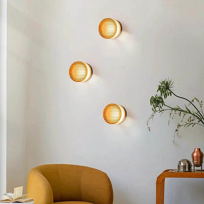 Nordic LED Wall Sconce: three round wooden-slatted wall lights mounted on a white living room wall.