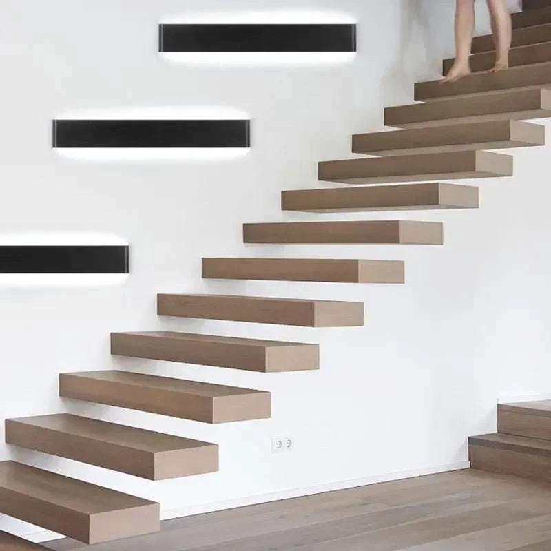 Minimalist Aluminium LED Wall Light with multiple units along a white staircase wall casting up and down glow