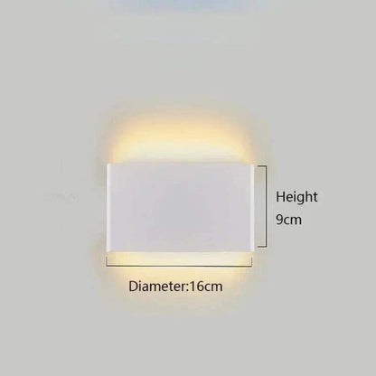 Minimalist aluminium LED wall light mounted on bedroom wall; white finish with up and down glow.