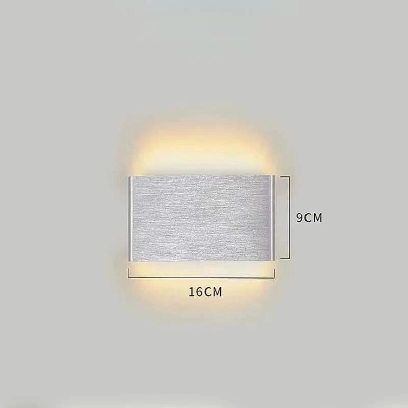 Minimalist aluminium LED wall light mounted on wall, emitting warm up and down lighting in silver finish.