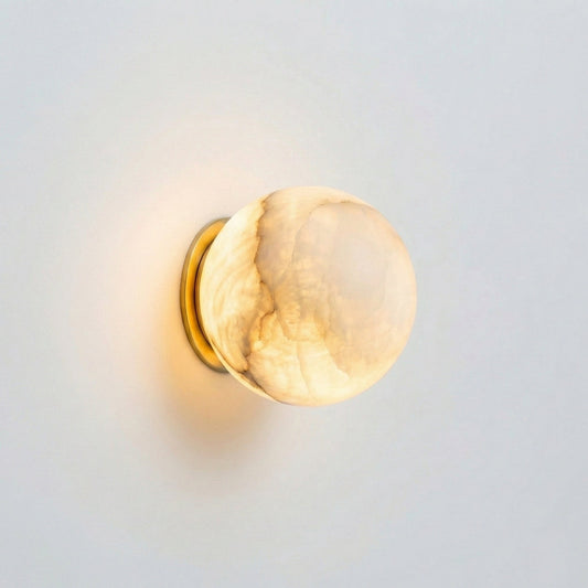 Wall-mounted light fixture with a gold frame and beige glass shade on a light gray background