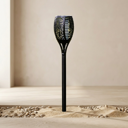 Black decorative garden torch on sand with a neutral background