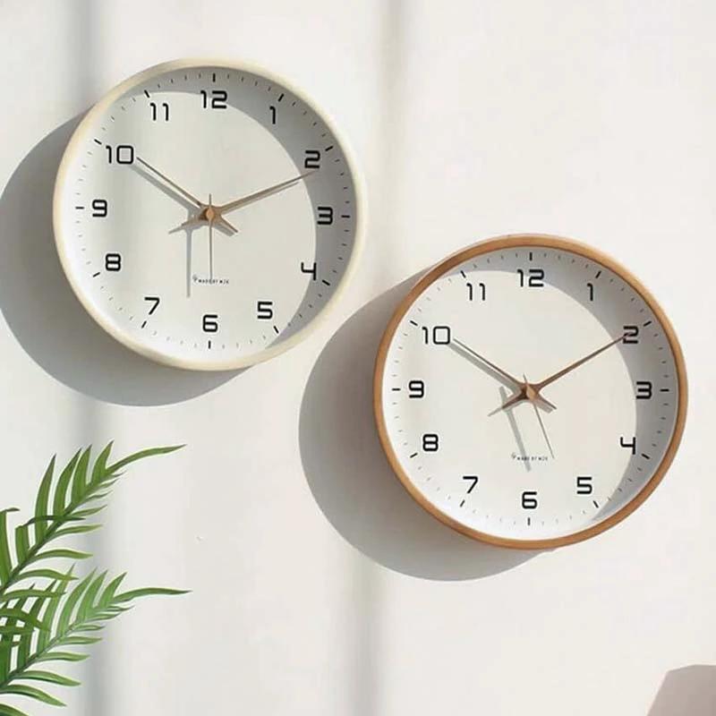 Nordic Wooden Wall Clock, two minimalist wall clocks with white faces and natural wood frames mounted on a white wall.