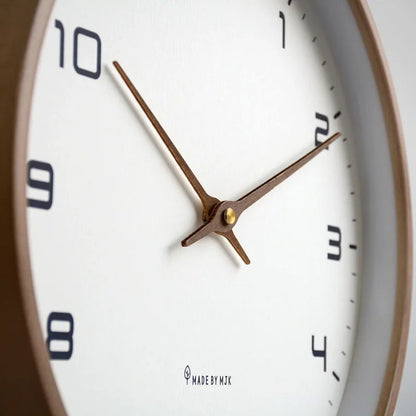 Nordic Wooden Wall Clock with white dial, black numerals and brown hands, Made by MTK, mounted on wall.