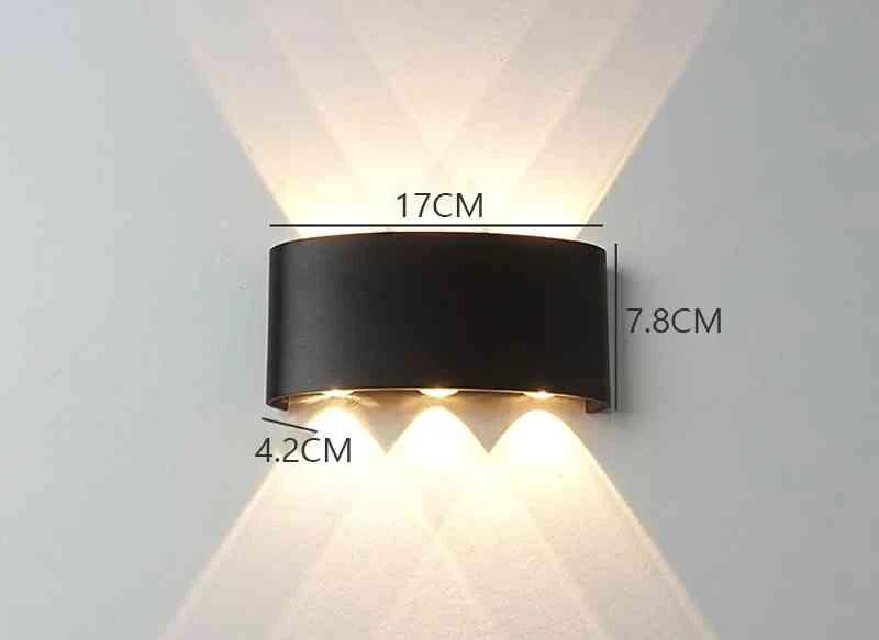 Modern Outdoor LED Wall Lamp, black metal mounted on wall, emits upward and downward glow for garden or living room.