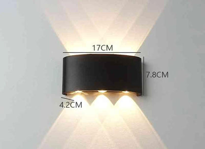 Modern Outdoor LED Wall Lamp, black metal mounted on wall, emits upward and downward glow for garden or living room.