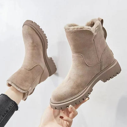 Tessa beige laars vastgehouden in de hand, zijaanzicht met profielzool